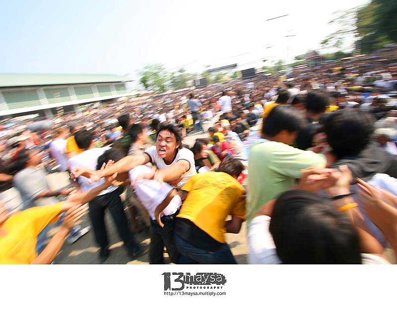 หลวงพ่อนั่งสงบไม่ไหวติง แสดงถึงบารมีอันแก่กล้าพร้อมด้วยเหล่าพระอาจารย์ลูกศิษย์นั่งรายล้อมในปะรำพิธีอ