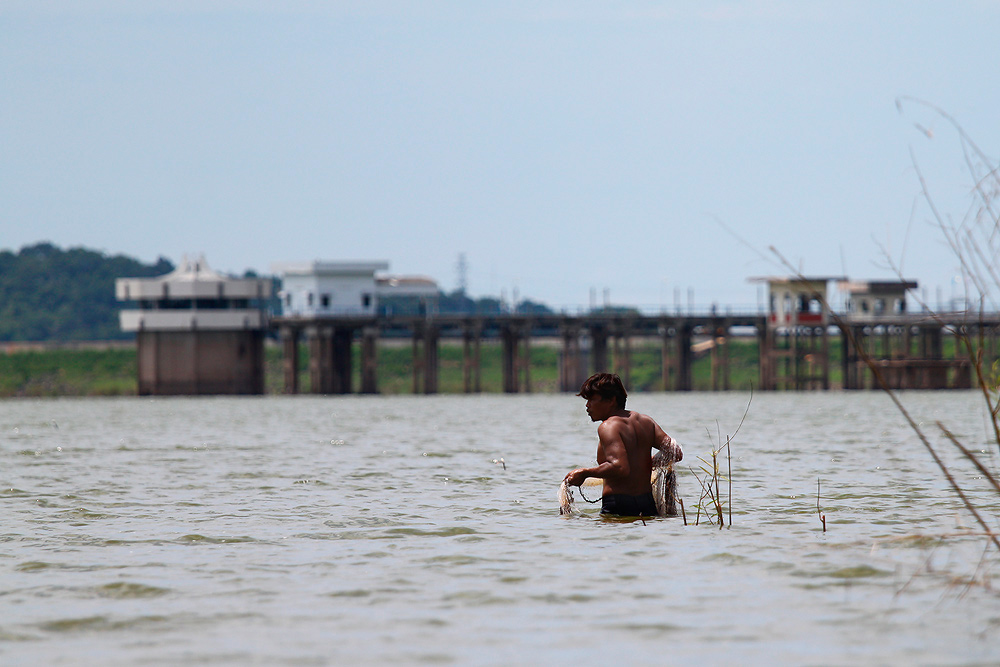 พายเรือ เลยมาอีกนิด  ก่อนถึงฝั่ง  เห็นชาวบ้านอีกคน คอยจ้องทอดแห