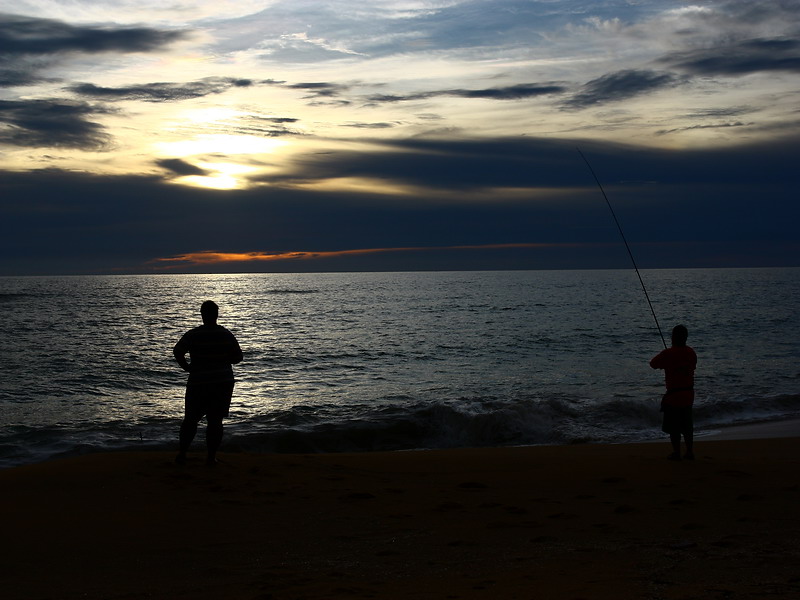  [b]ชายหาดในยามเย็น ที่เห็นเป็นวงดำๆในน้ำข้างหัวอ้ายยักษ์นั่นคือ ฝูงลูกปลาจำนวนมากโดนปลาใหญ่ไล่งับอย