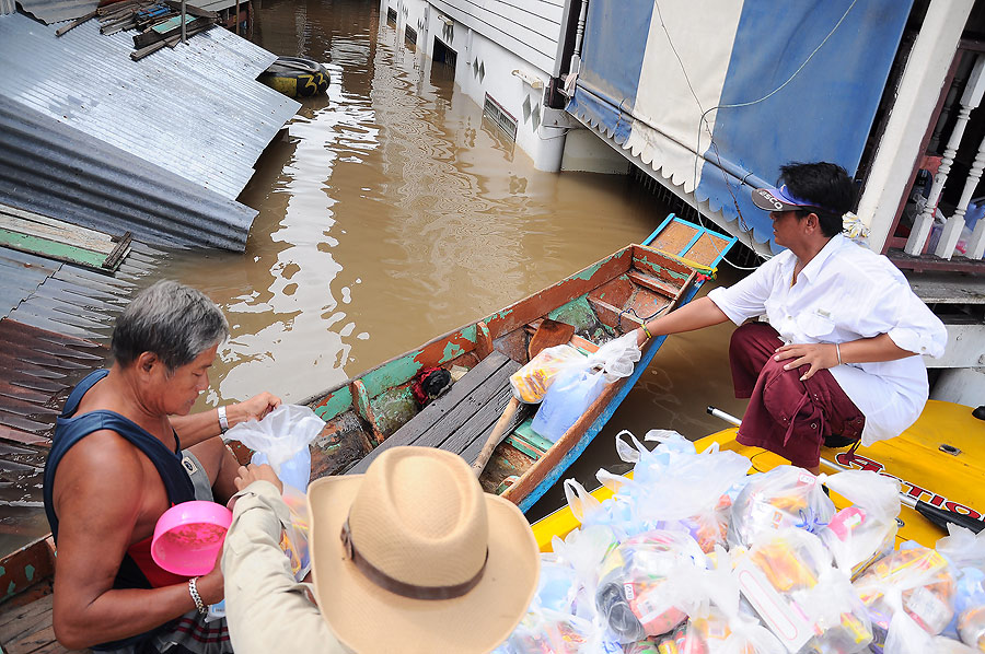 จุดที่เรือผมเข้าไม่ได้ชาวบ้านที่มีเรือก็พายออกมารับถุงยังชีพไป และฝากไปให้เพื่อนบ้านที่อยู่ติดกันด้ว