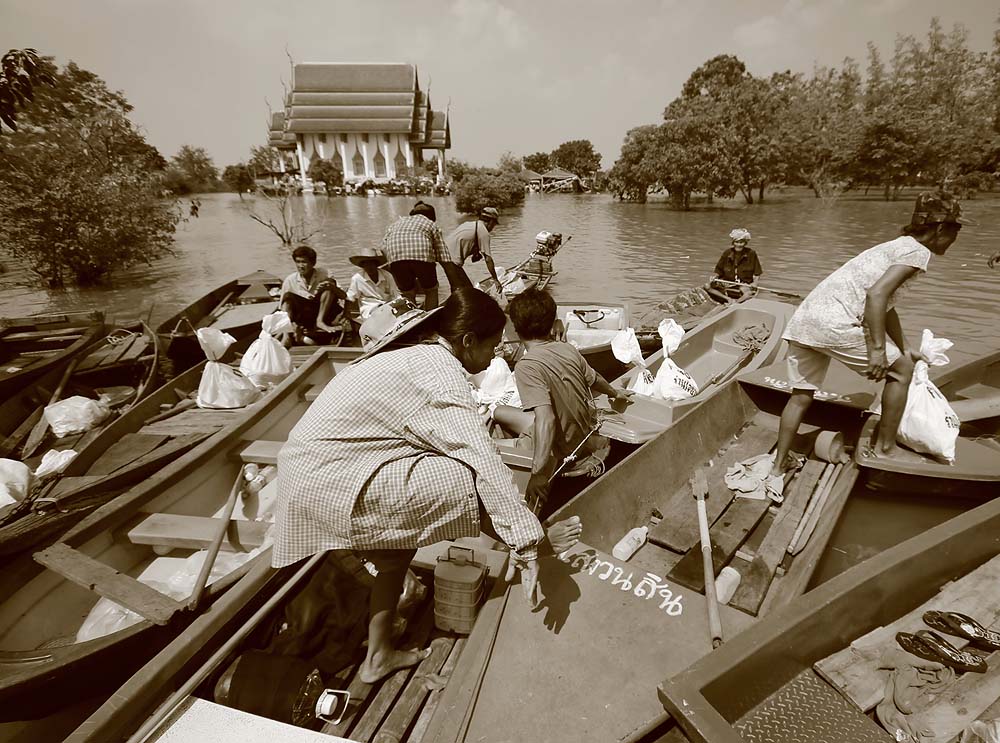 บางคนที่ไม่มีเรือ ก็อาศัยเรือของเพื่อนบ้านมารับของแจก