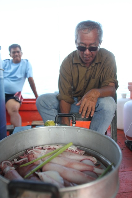 ด้านหลังเรือ อาจารย์นพพี่ใหญ่ของเรา จัดการนึ่งหมึกสดๆตักจากห้องขังเหยื่อ