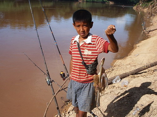 เด็กน้อยที่รักในการตกปลา